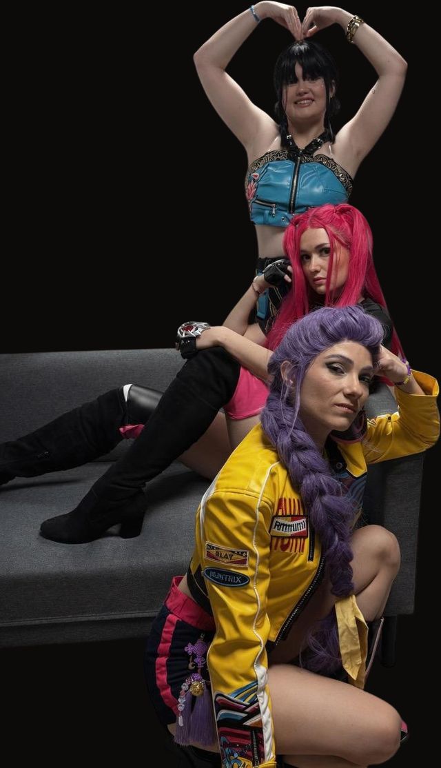 Zoey, Mira et Rumi, les Huntrix de KPop Demon Hunters, incarnées par La Casa du Cosplay, posent sur un canapé.